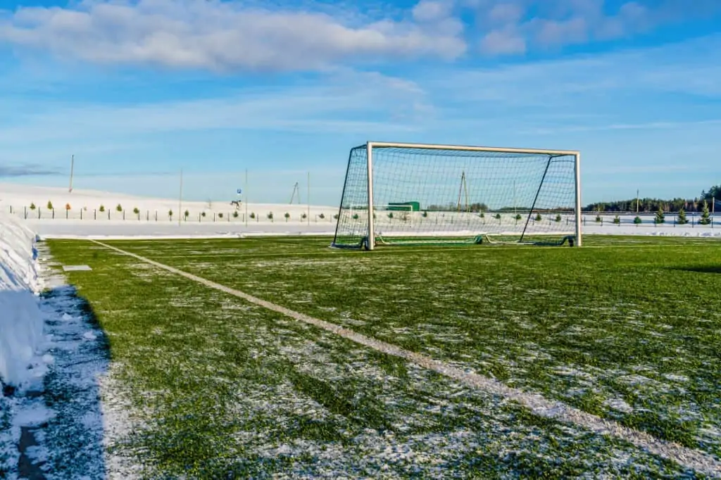 Empty Soccer Field in the Winter Partly Covered in Snow - Sunny Winter Day, Concept of Winter Sports and Game (1)