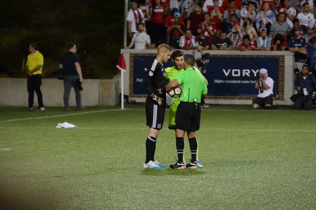 Soccer referee with two players