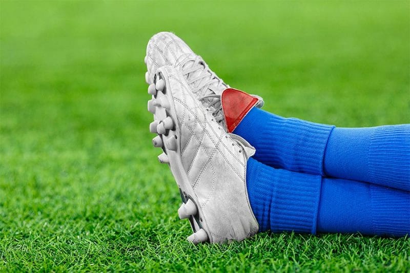 soccer players cleats and socks lying on grass - soccer compression socks