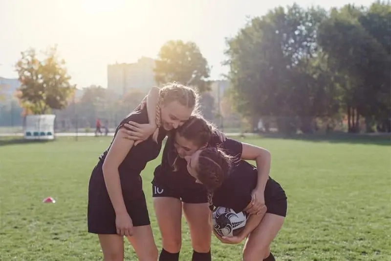 soccer players hugging having fun