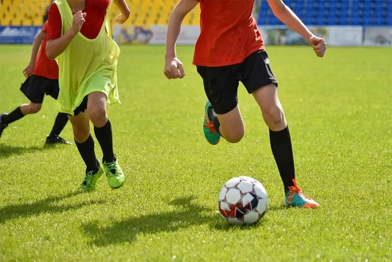 soccer training match with three players running (playing soccer FAQ)