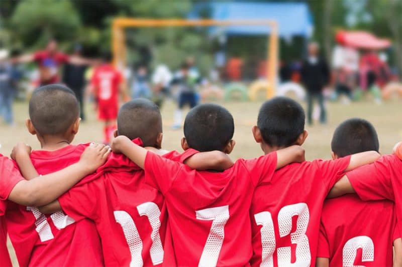 youth boys soccer team with arms linking