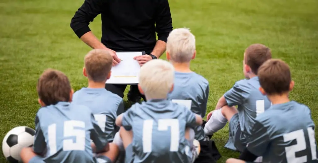 Soccer Coach Explaining Tactics to Youth Players.