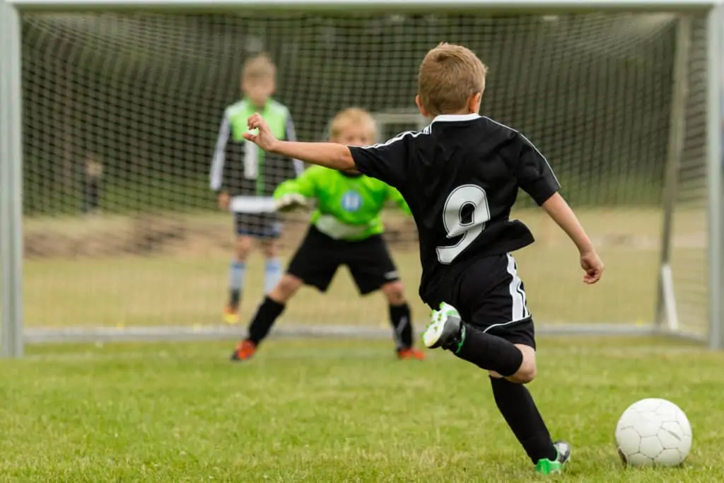 Soccer Player Kid Shooting At Goal
