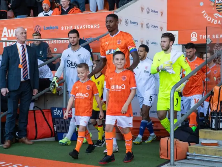 Marvin Ekpiteta 21 of Blackpool leads his side out with the team mascots ahead of the Sky Bet Championship match Blackpool vs Watford at Bloomfield Road Blackpool United Kingdom 8th October 2020. ○ Soccer Blade