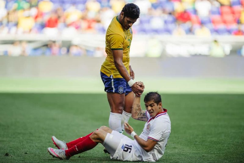Brazil's Hulk helping a player off the ground