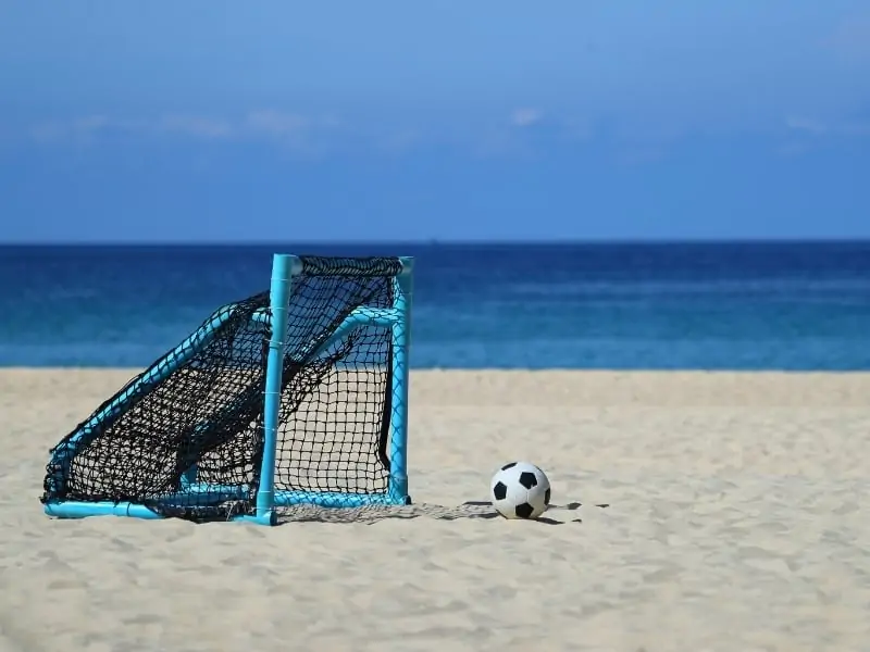 Soccer ball and goal on a beach