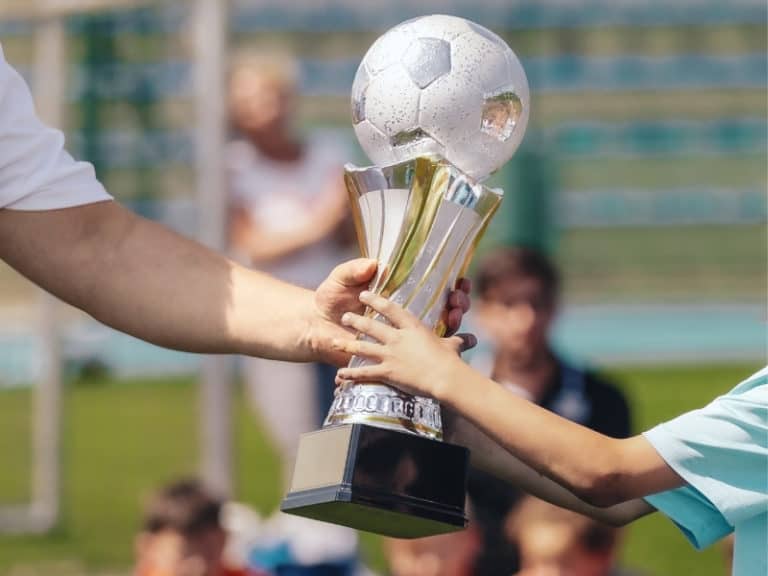 Soccer trophy passed from a coach to a player