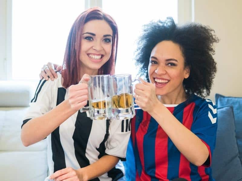 Two female soccer fans drinking