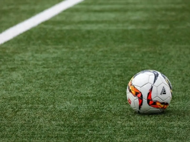 White Adidas soccer ball on a field