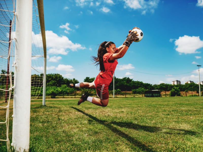 Female Goalkeeper Catching a Ball in A Save.