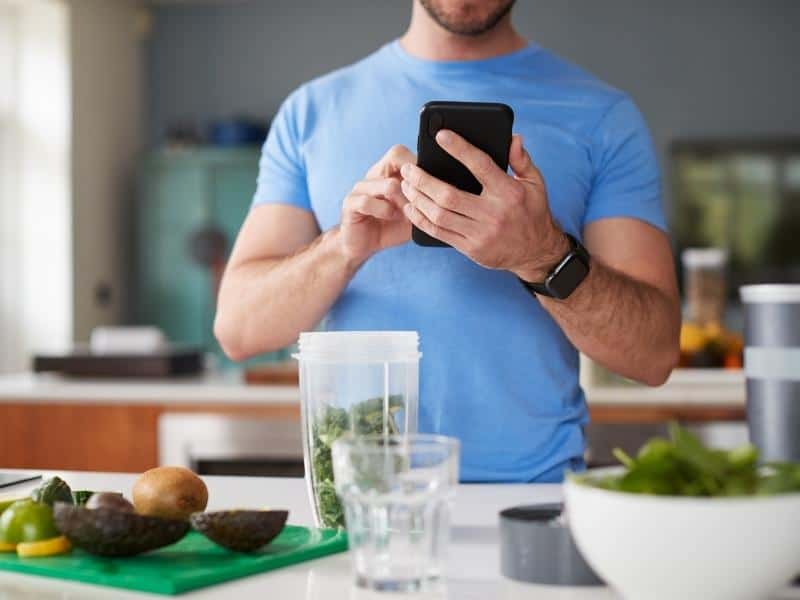 Man calculating calories of food in a kitchen