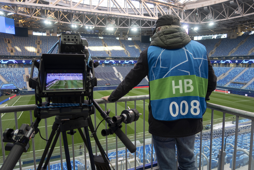 Behind a video camera on the stand at a soccer game