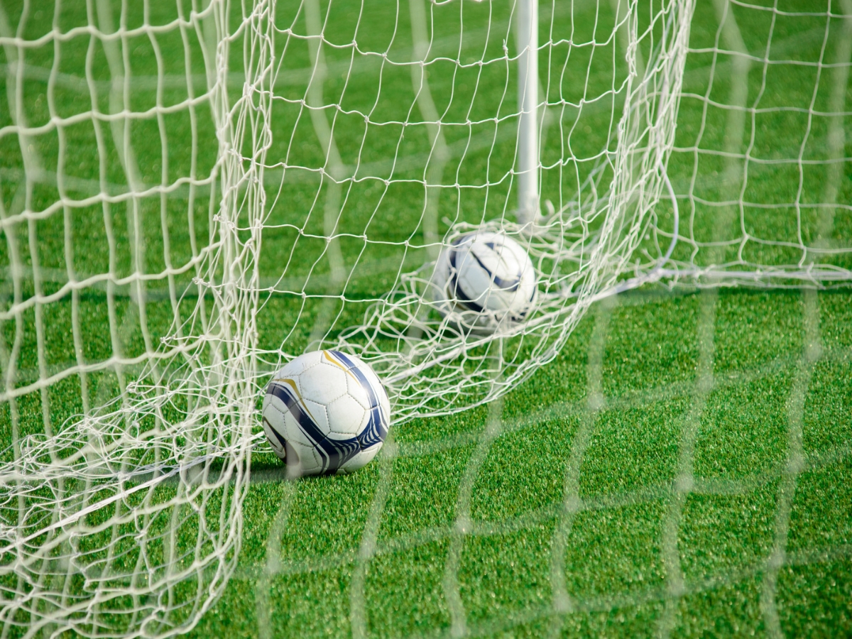 Soccer balls in a goal during a training session. ○ Soccer Blade