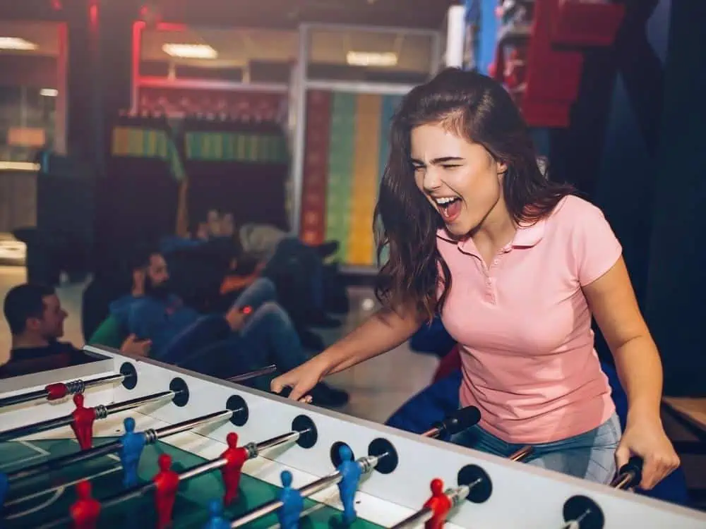 Woman playing table soccer tshirt and jeans