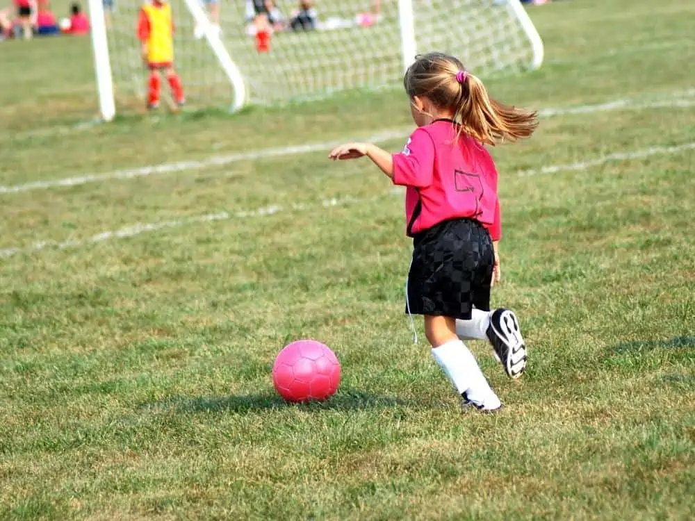 Girl Dribbling a Pink Soccer Ball