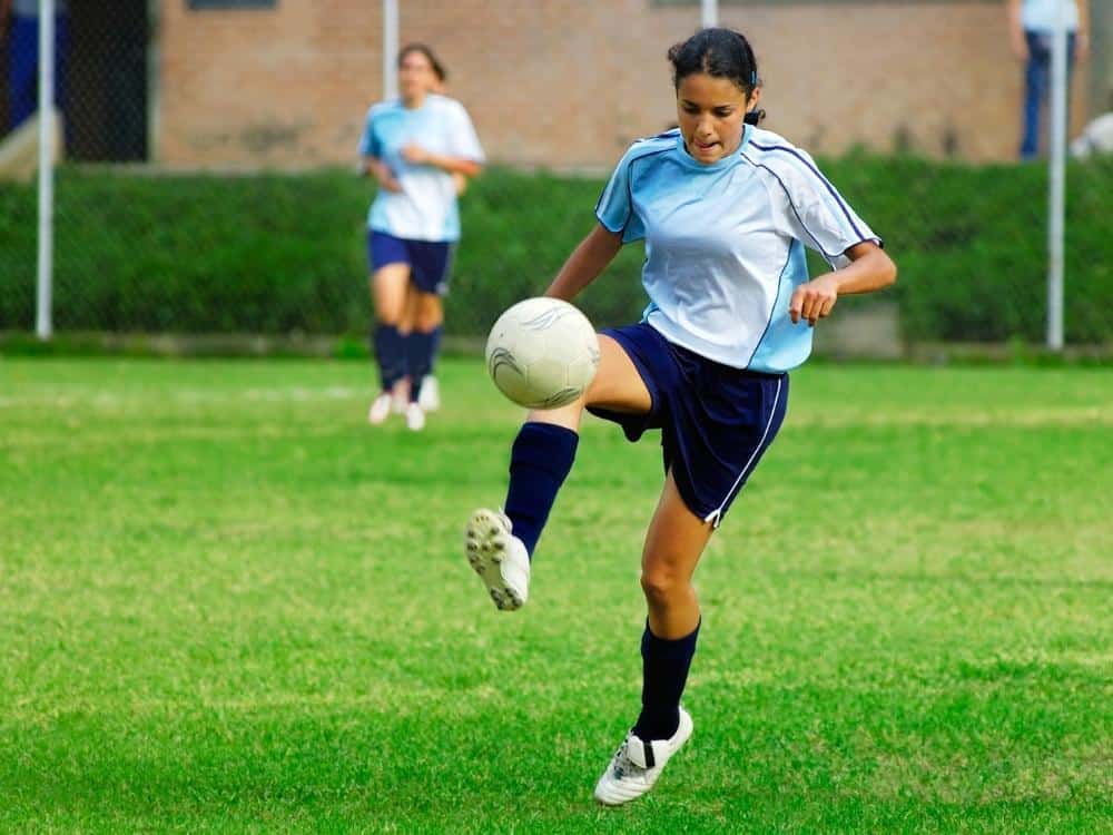 Teenage Girl Controlling a Soccer Ball in a Game