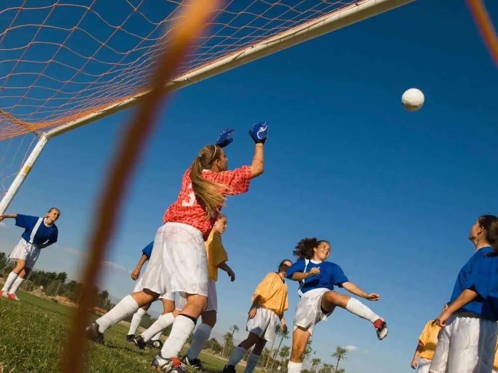 Teenage Girl Soccer Game During a Cross Image From Bottom Corner of Goal