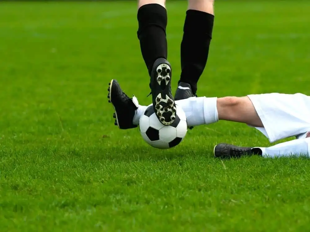 Soccer player slide tackling and wining the ball