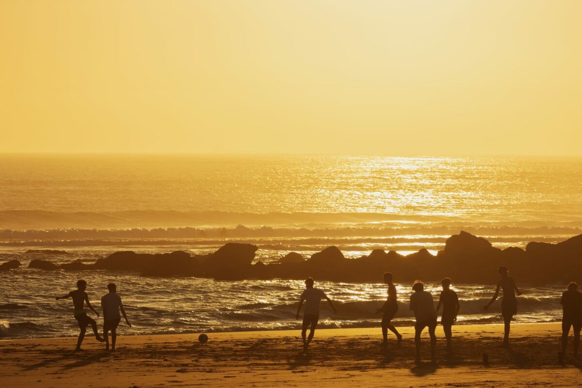 Teenage boys playing soccer on the beach at sunset ○ Soccer Blade