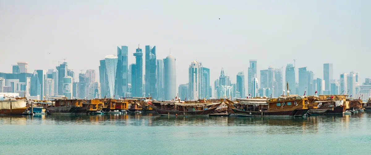 DOHA QATAR CIRCA AUGUST 2019 Midday view of Doha cityscape with traditional dhow boats in the foreground. ○ Soccer Blade