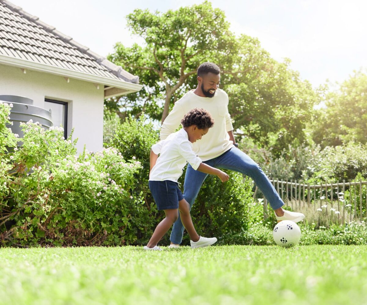 Shot of a father and son playing soccer together outdoors. ○ Soccer Blade