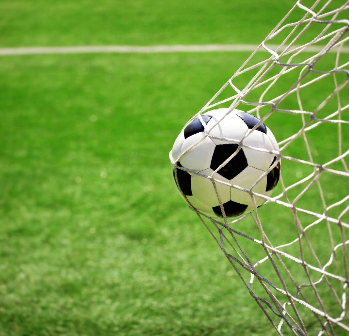 Wilson soccer ball hitting the back of a goal. ○ Soccer Blade