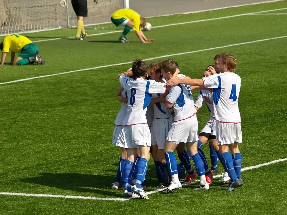 Youth soccer players celebrating a goal. ○ Soccer Blade
