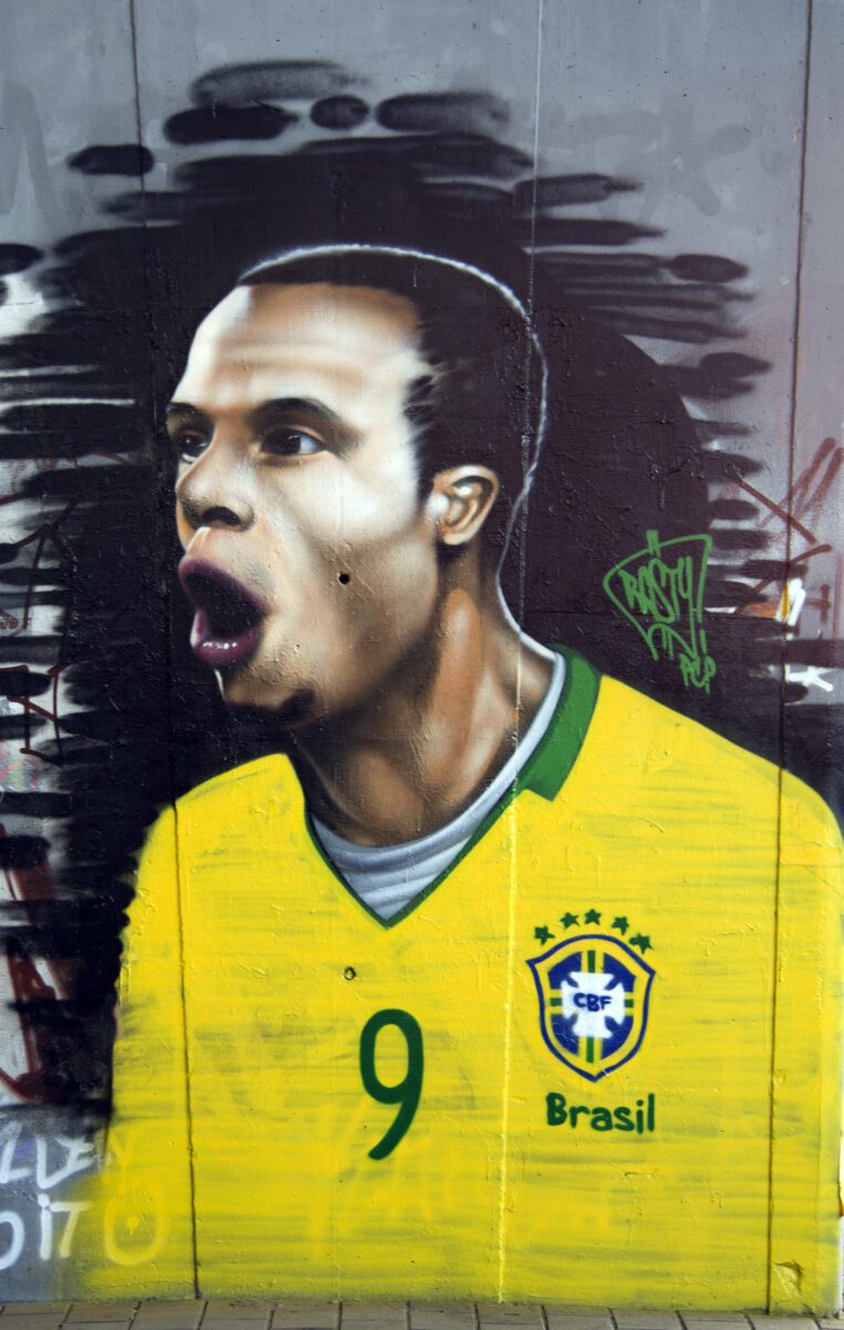 Graffiti on a wall depicting a brazilian soccer player ○ Soccer Blade