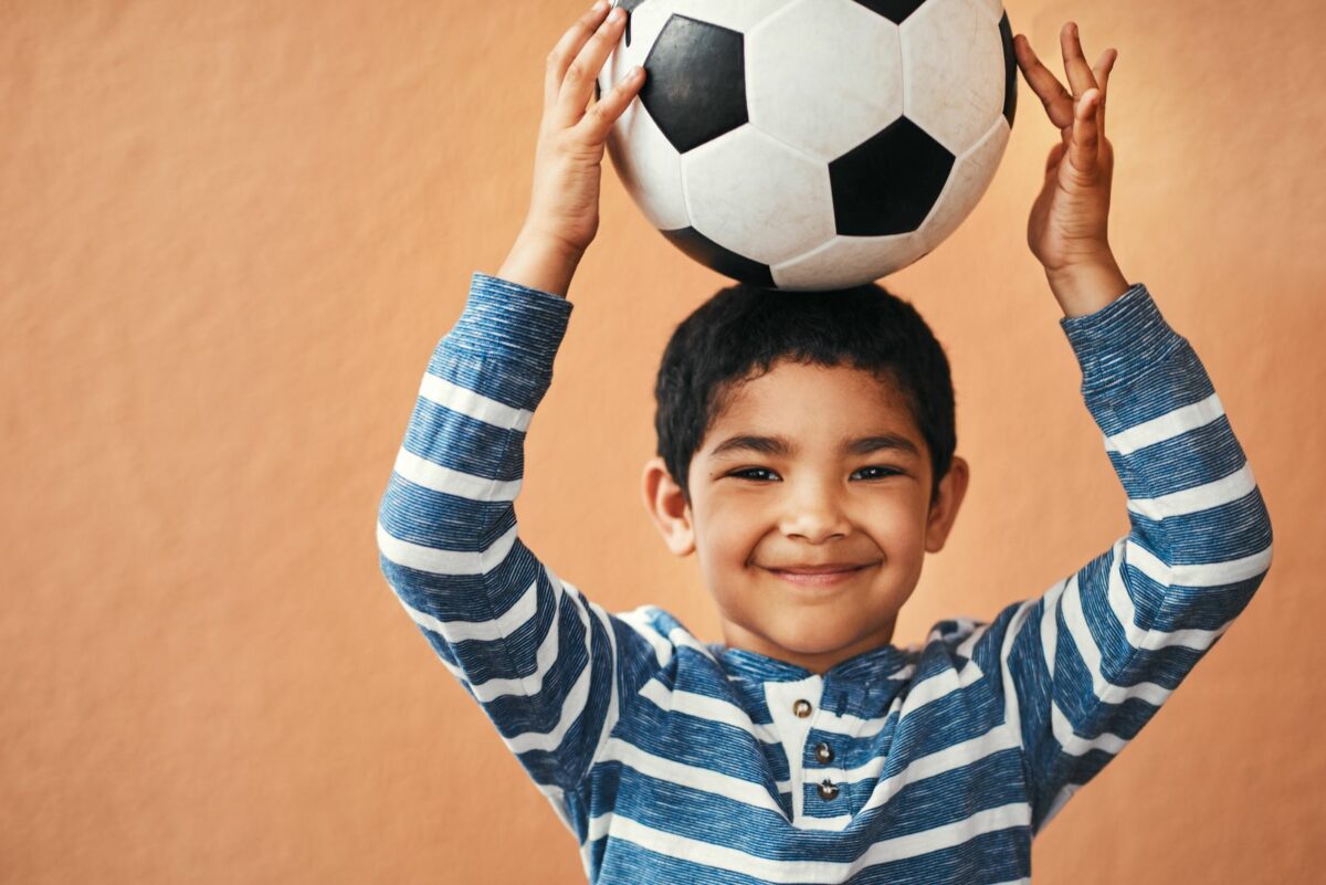 Portrait of an adorable little boy posing with a soccer ball ○ Soccer Blade