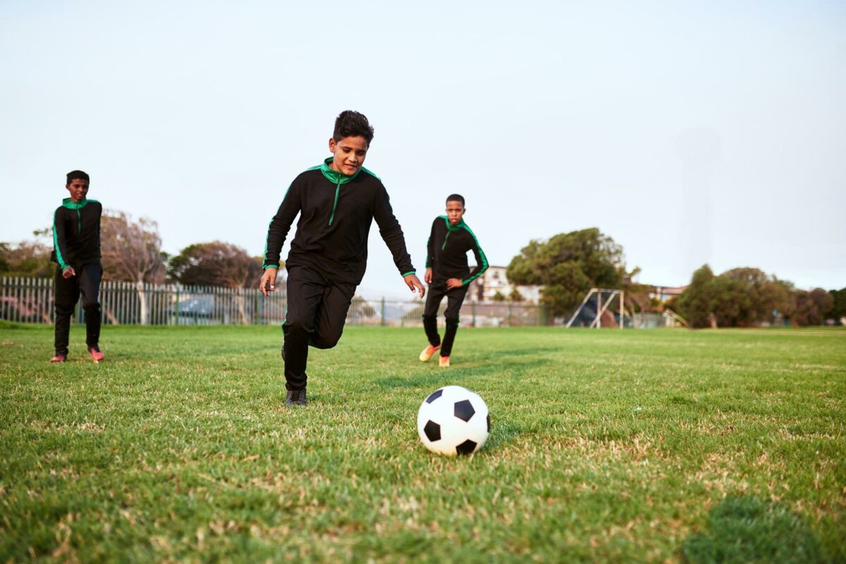 Soccer develops agility speed and stamina. a group of young boys playing soccer on a sports field ○ Soccer Blade