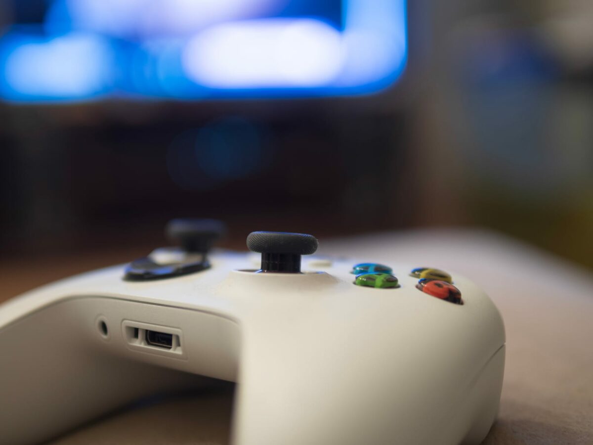 Close up view of White Xbox Controller and TV background ○ Soccer Blade